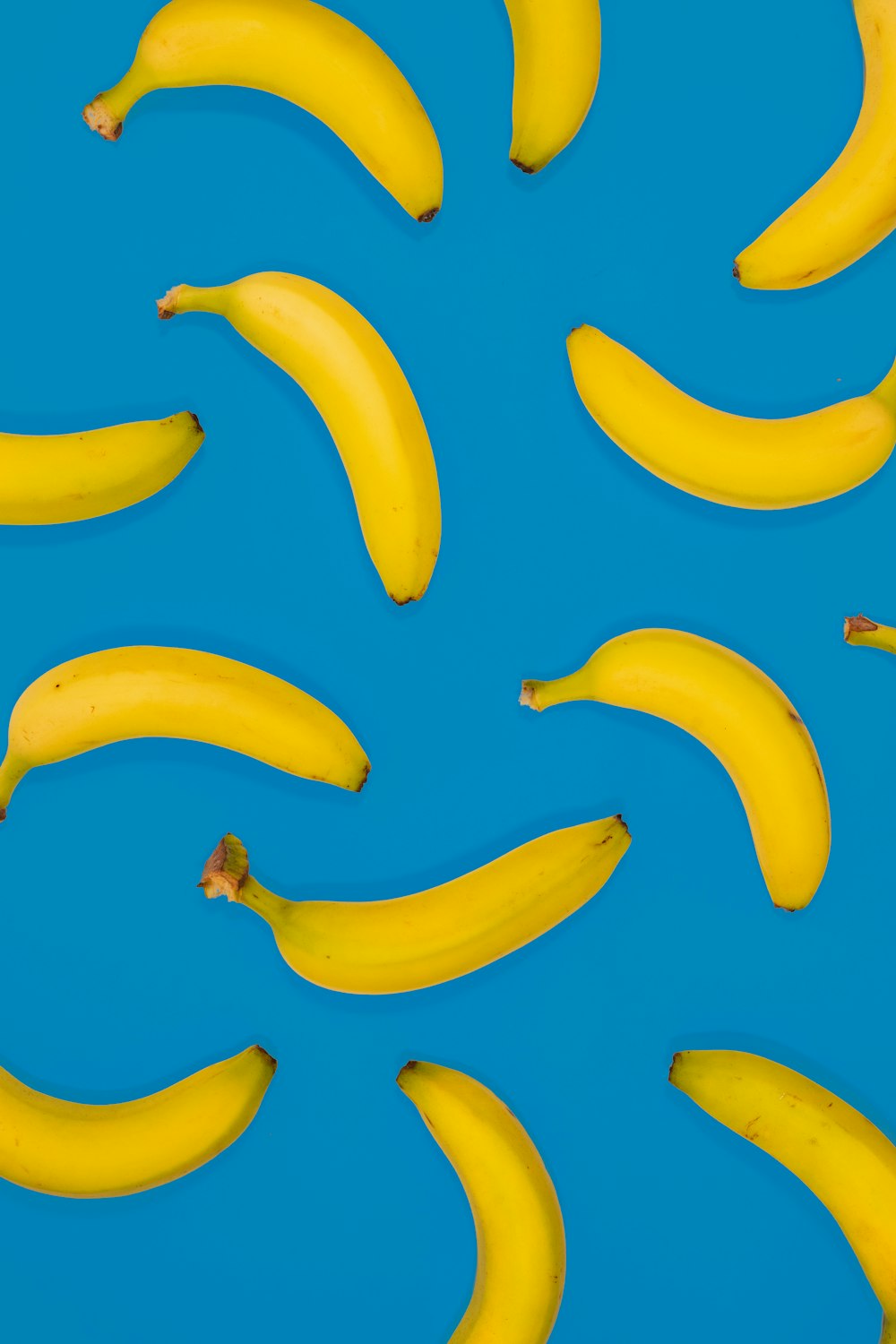 yellow banana fruits on blue surface