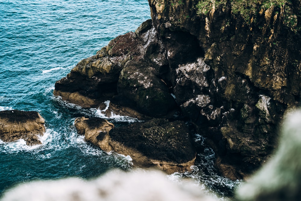 brown rock formation beside body of water during daytime