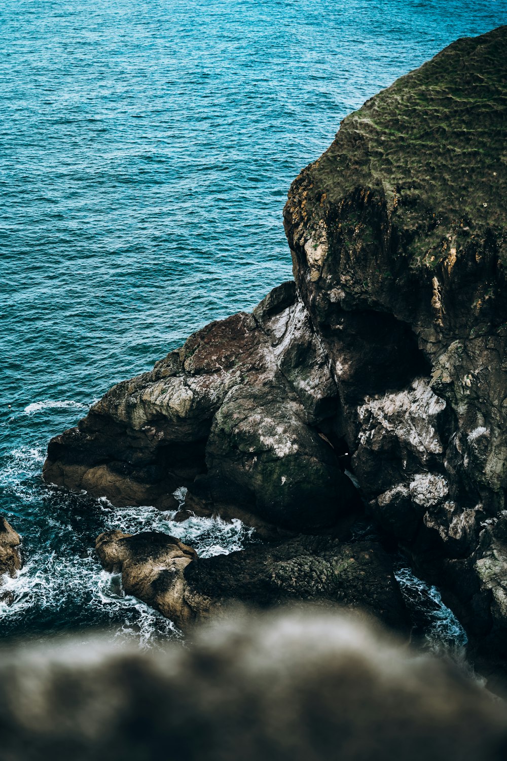 brown rock formation beside body of water during daytime