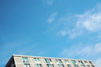 A well-maintained apartment building under a bright blue sky.