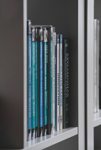 books on white wooden shelf