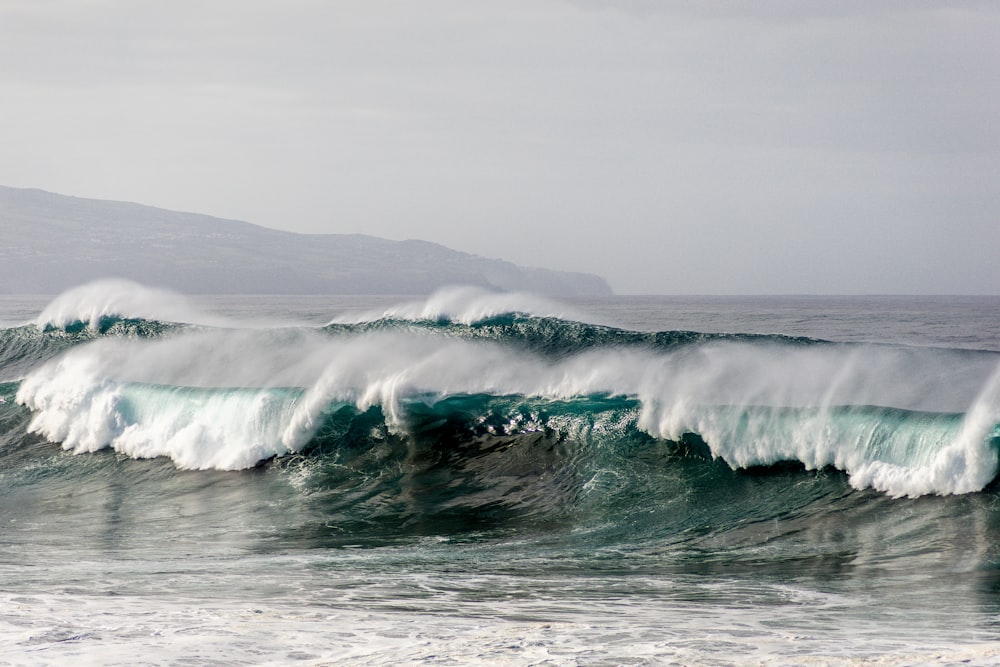 ocean waves crashing on shore during daytime