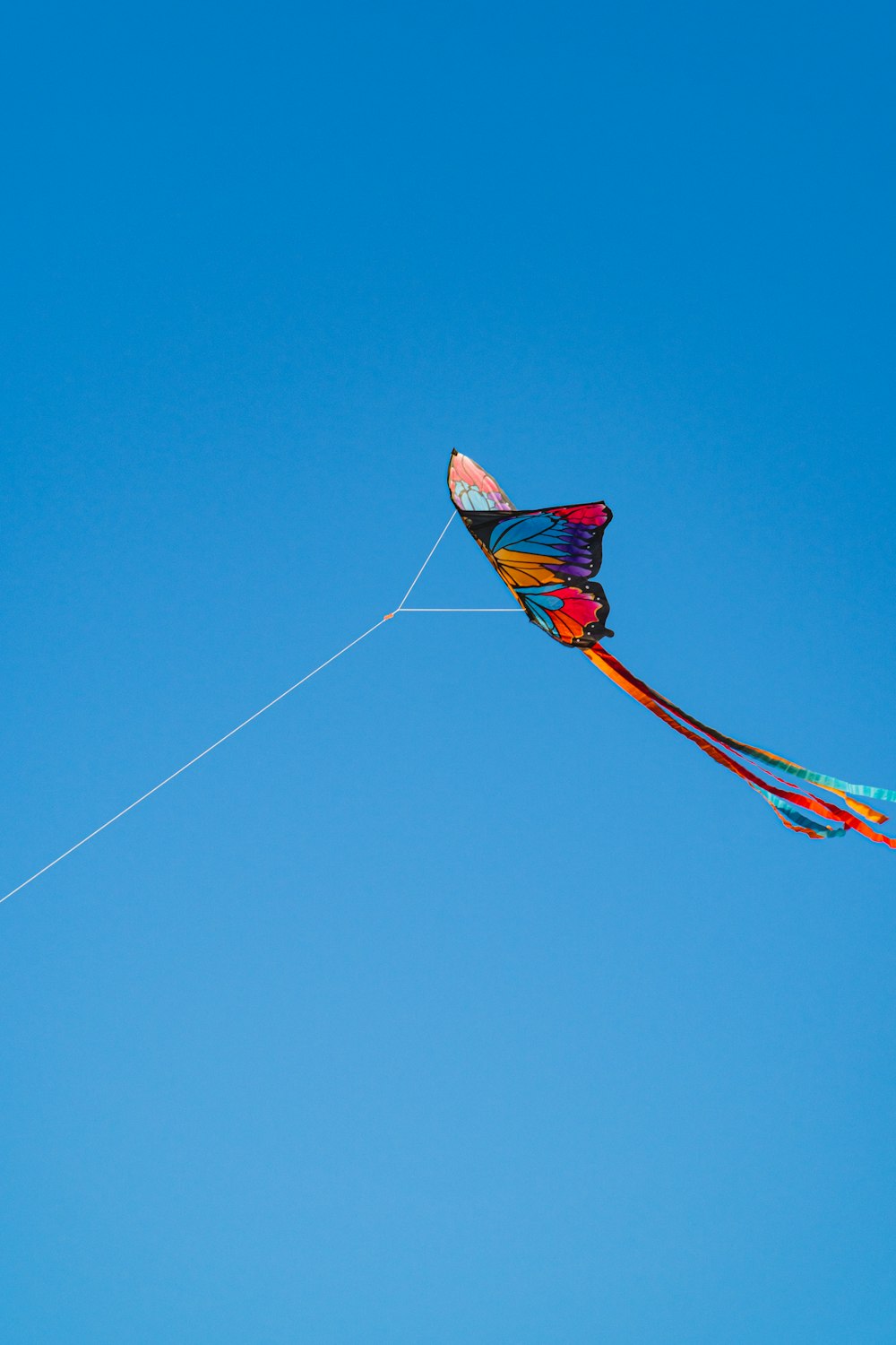 red and yellow kite flying under blue sky during daytime