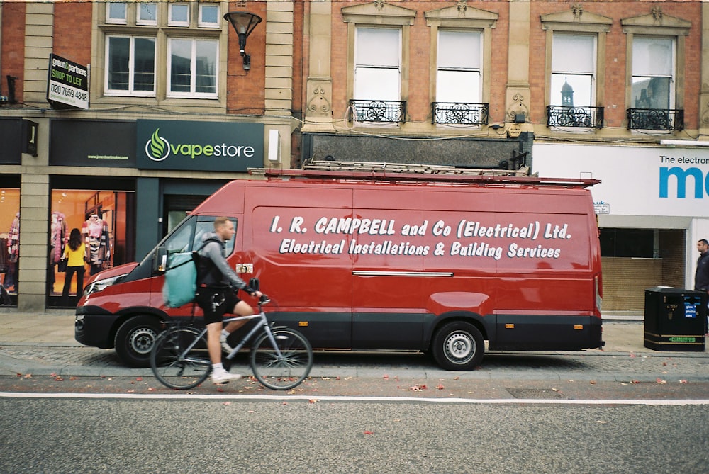 red and white van parked beside brown concrete building during daytime