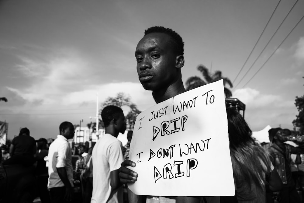 grayscale photo of man holding white printer paper