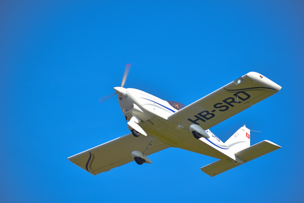 white and blue airplane under blue sky during daytime