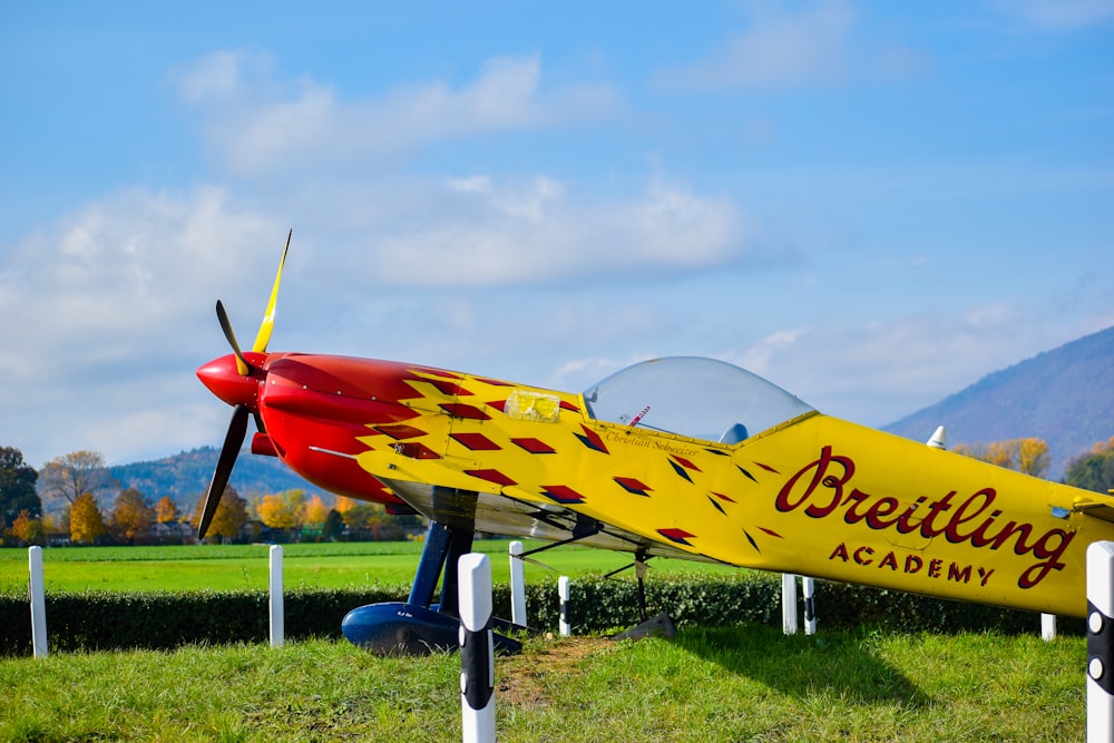 blue and yellow jet plane on green grass field under white clouds and blue sky during