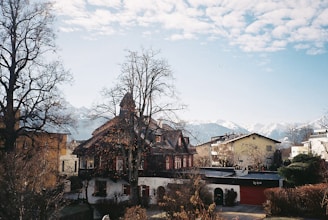 A peaceful village scene in Nagari Sitombol with traditional houses and lush greenery under a clear sky.