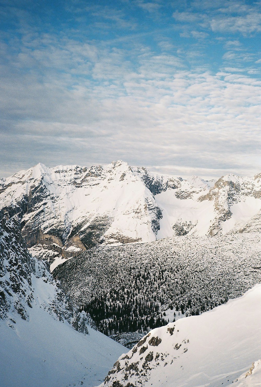 snow covered mountain under cloudy sky during daytime