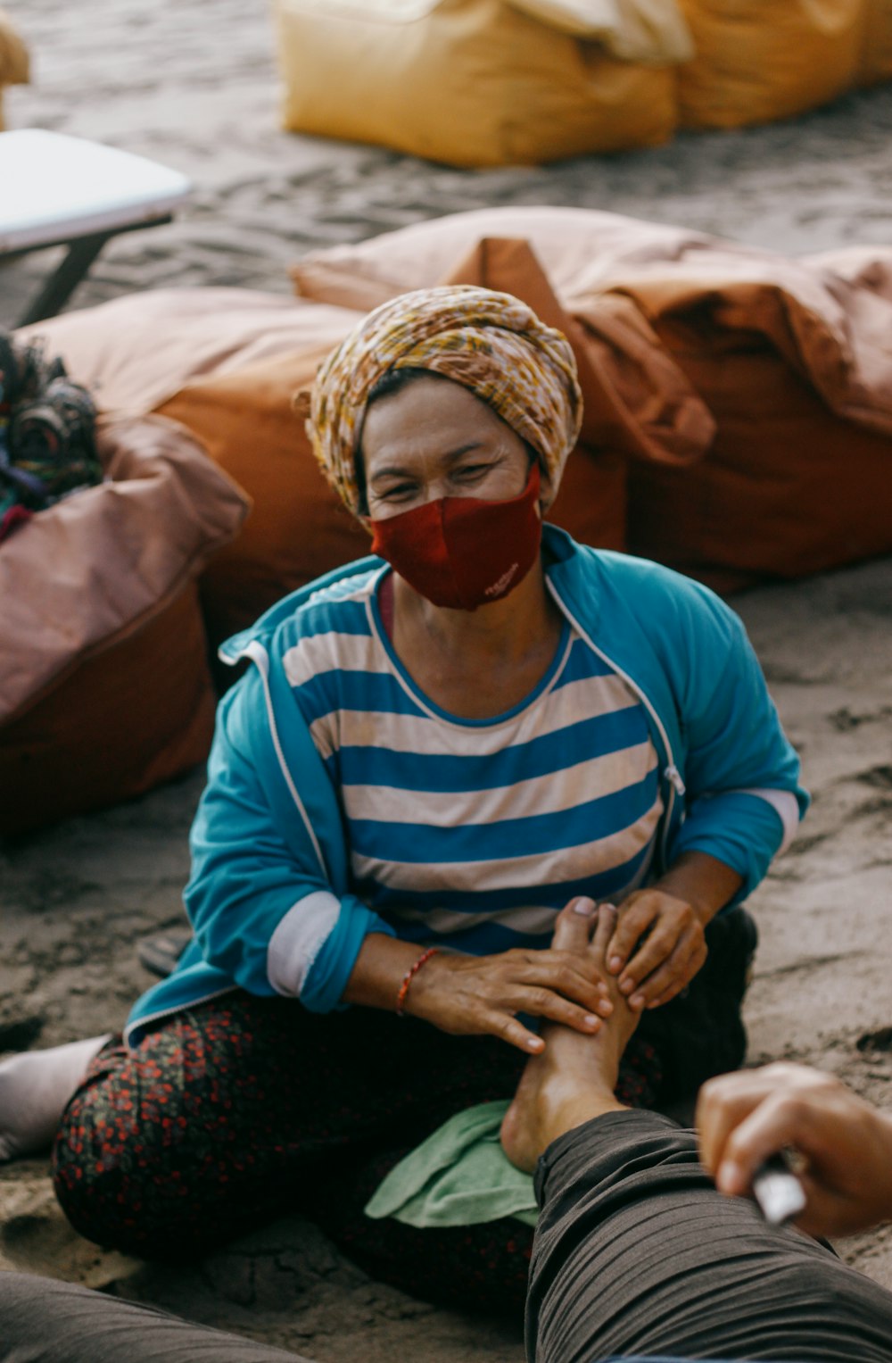 man in blue and white striped long sleeve shirt and red goggles sitting on sand during