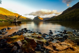 A serene lake reflecting the mountains during golden hour.