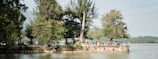Guests enjoying peaceful moments by Lake Toba, framed by forest green hills under clear skies.