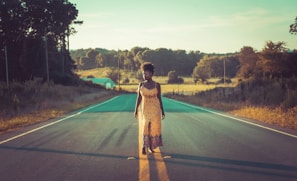 A bright yellow sundress hanging on a rustic wooden fence under a clear blue sky