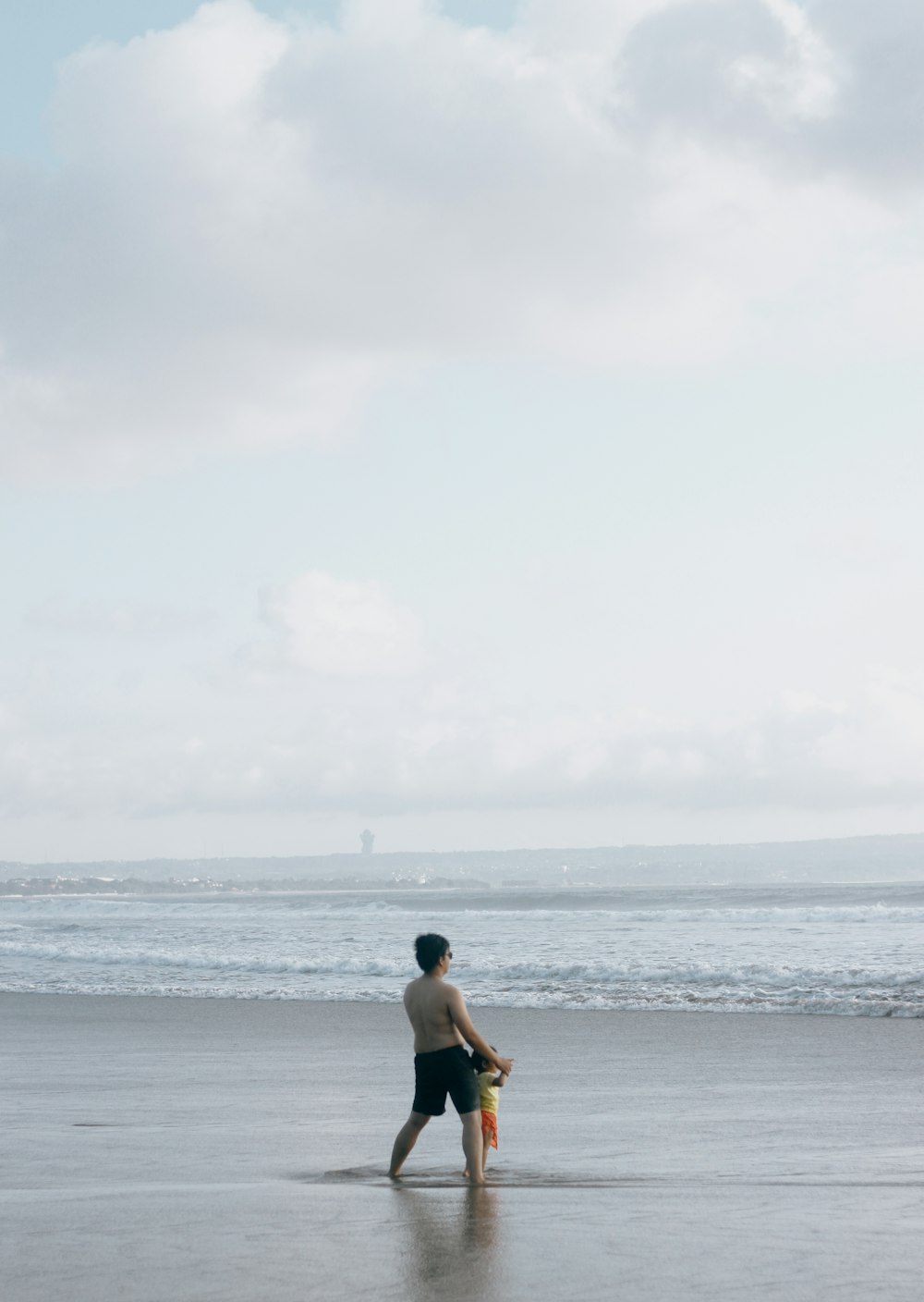 woman in black bikini standing on beach during daytime