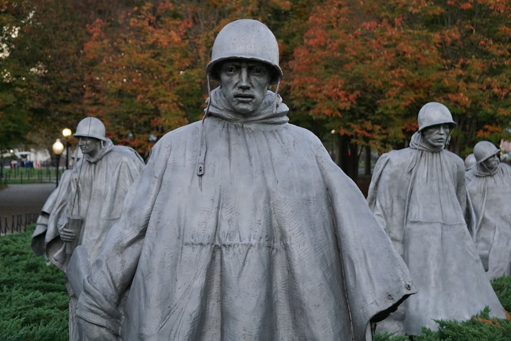 man in gray coat standing near green trees during daytime