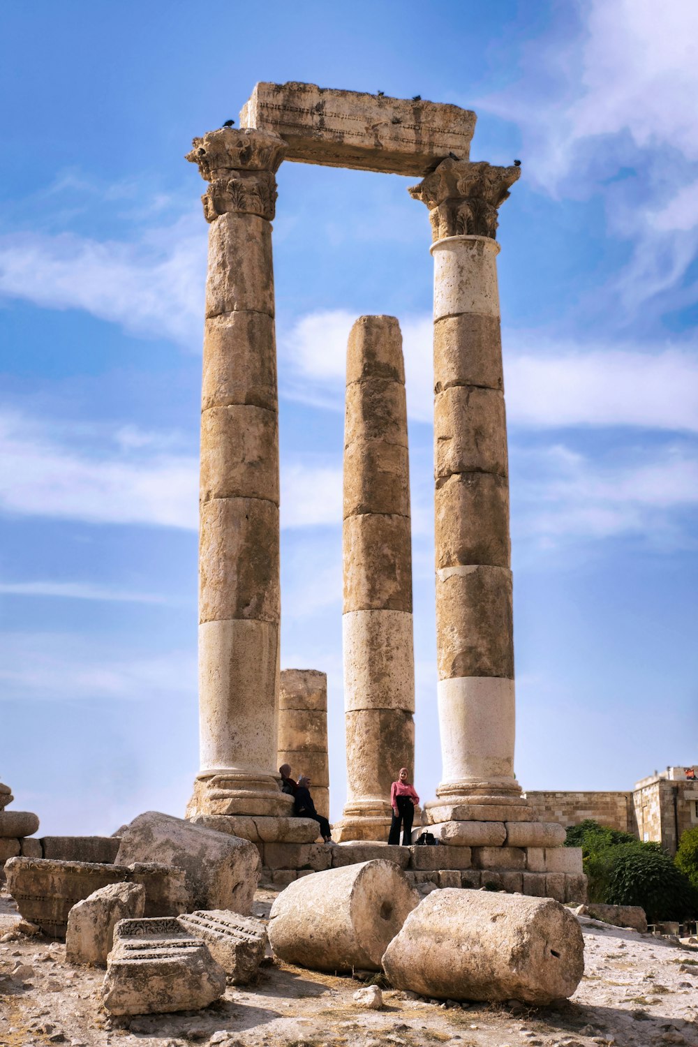 people walking on gray concrete pillar under blue sky during daytime