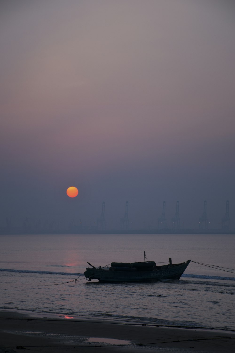 silhouette of boat on sea during sunset