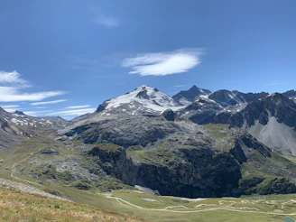 Mountain landscape with winding cycling trails under a clear sky, no people visible.