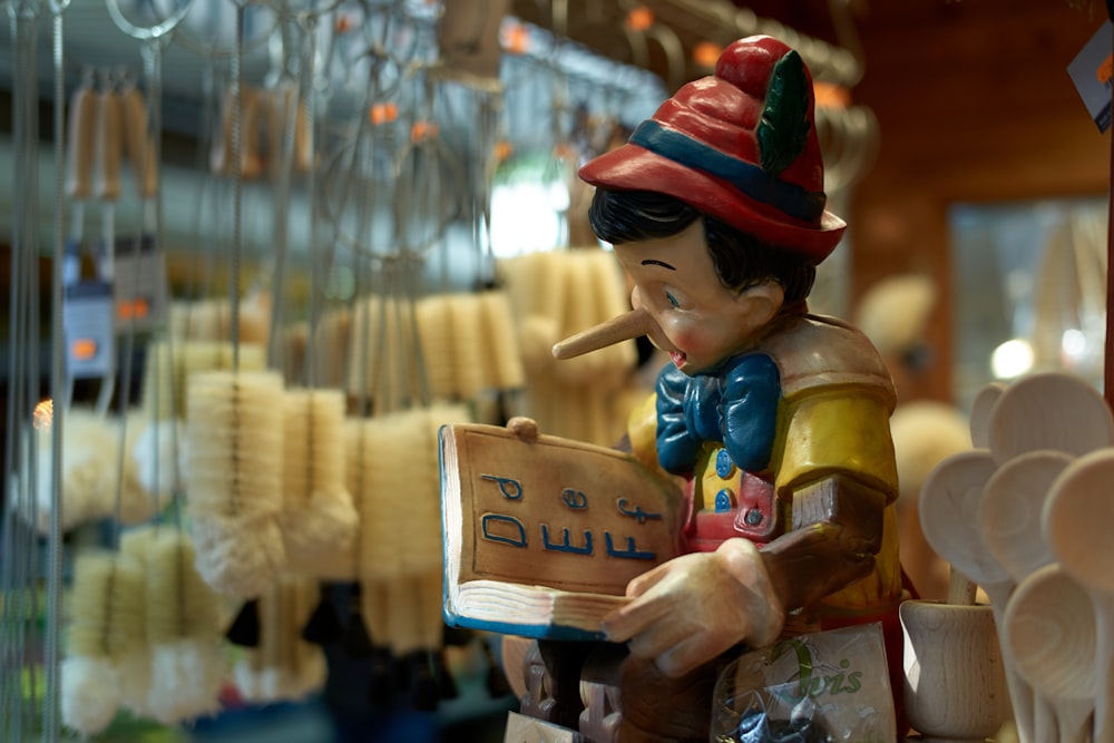 man in red hat holding brown wooden cross figurine