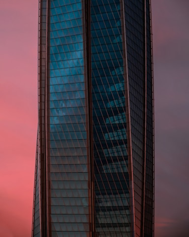 A sleek high-rise building photographed at golden hour, highlighting its glass facade.