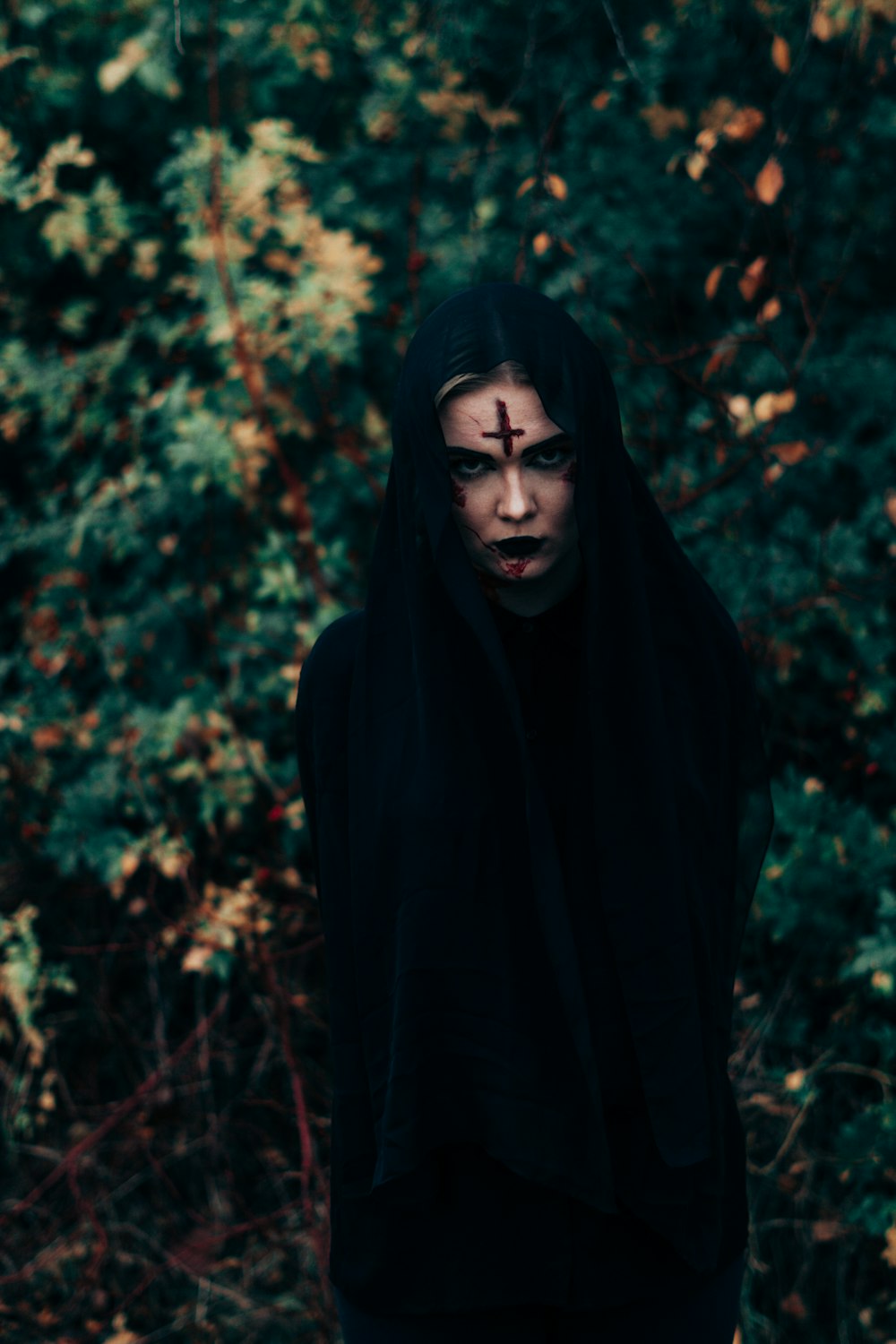 woman in black hijab standing near green trees during daytime