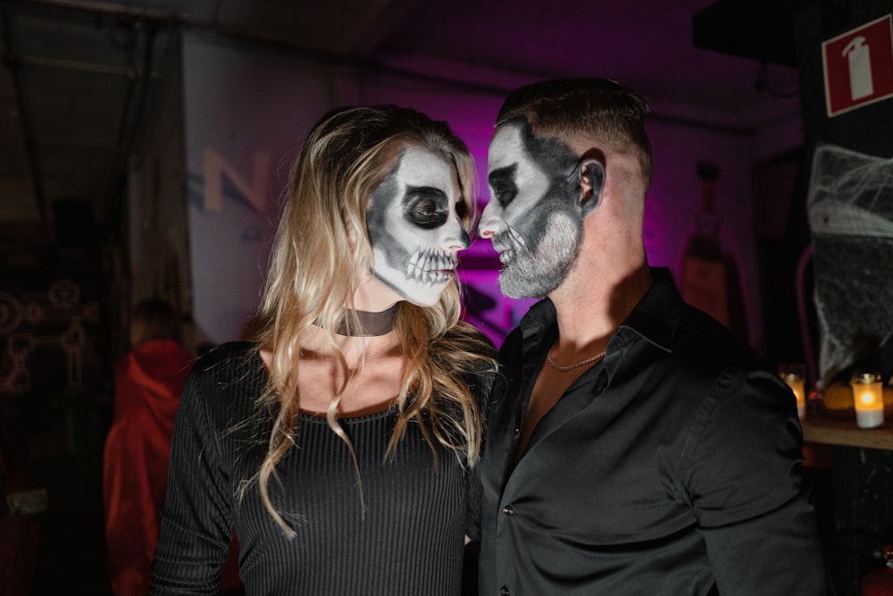 man in black dress shirt beside woman in white mask