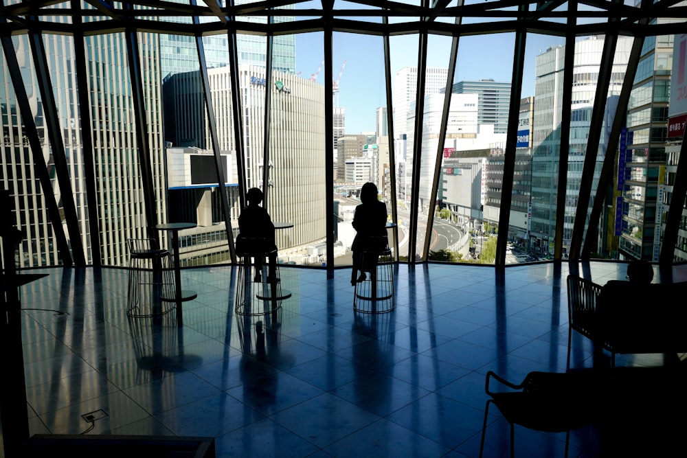 people sitting on chair in front of glass window