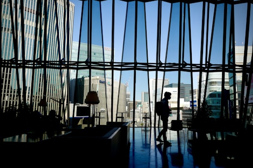 silhouette of man standing near glass window
