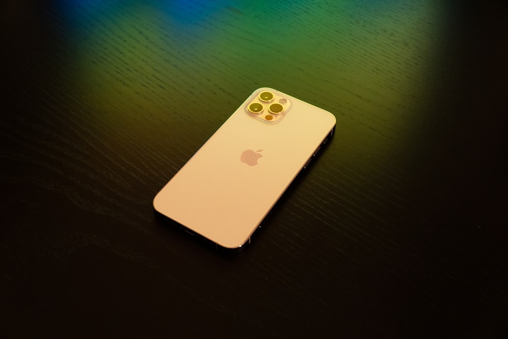 white iphone 4 on green wooden table