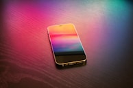 An artistic view of a smartphone with colorful light reflections.