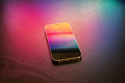 Close-up of a sleek smartphone displaying a colorful mood graph on a dark indigo background with violet glow accents.