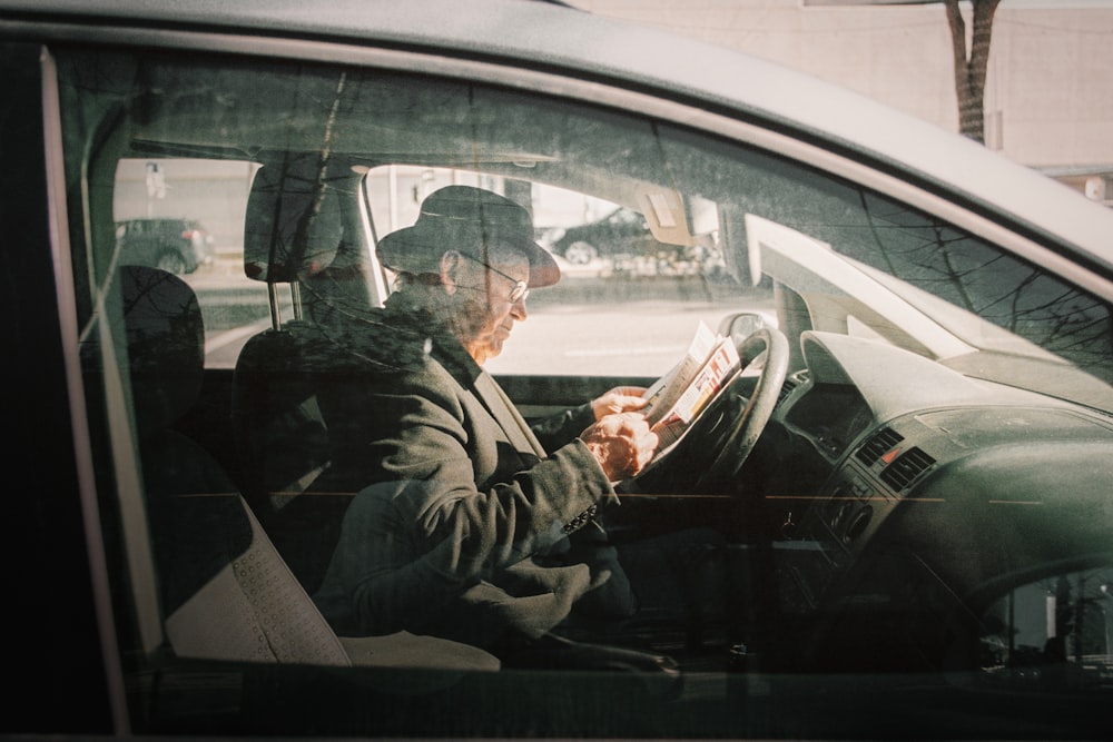 man in black jacket driving car