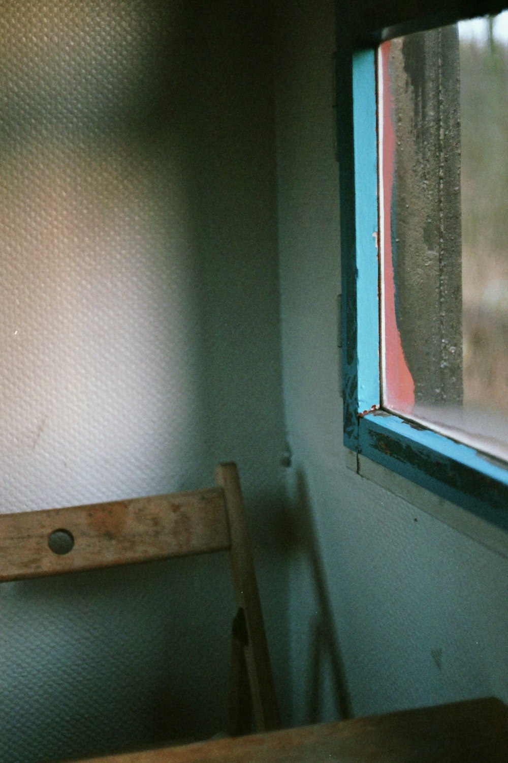 brown wooden seat beside white wall