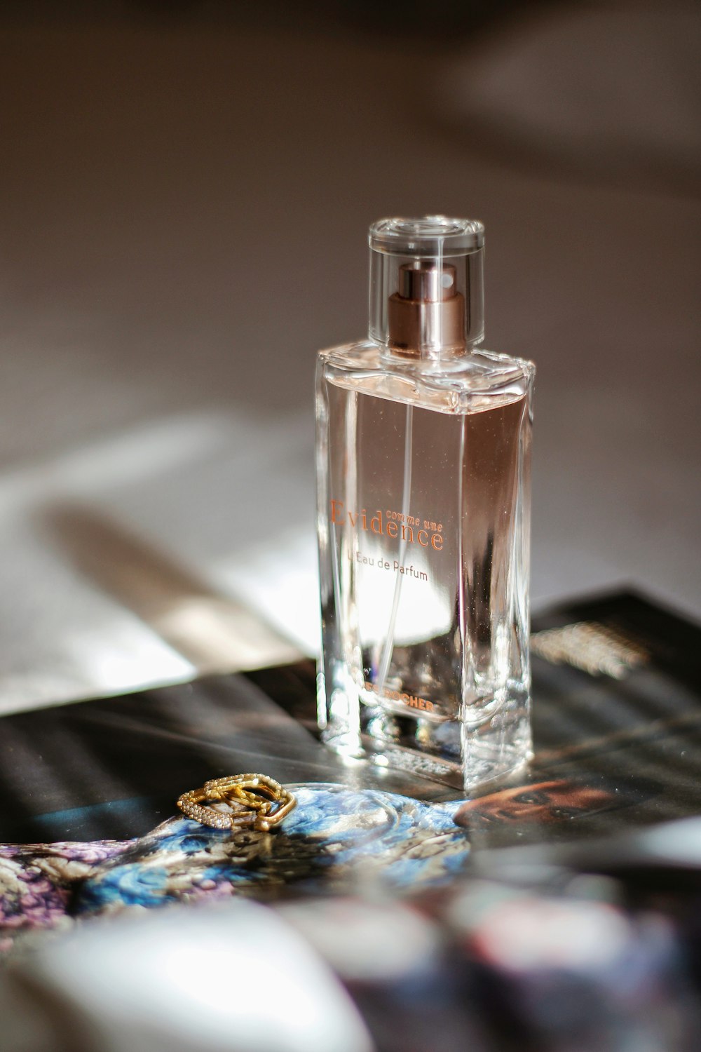 clear glass perfume bottle on black table