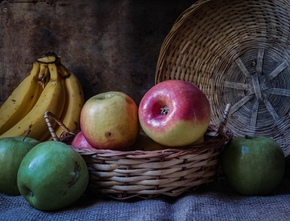 green apples and apples on brown woven basket