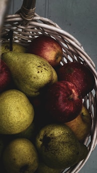 Freshly picked organic fruits and vegetables in a rustic basket.
