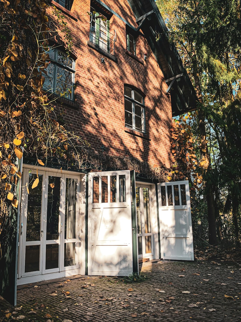 Casa de ladrillo marrón con ventana de vidrio enmarcada en madera blanca
