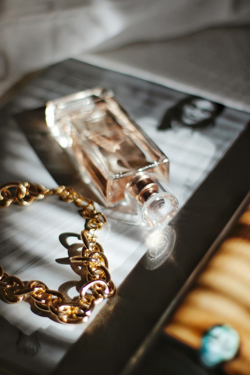 clear glass perfume bottle on black table