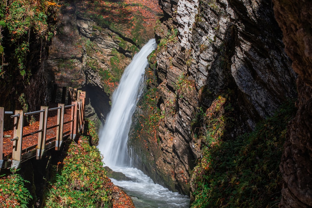 brown wooden bridge over waterfalls