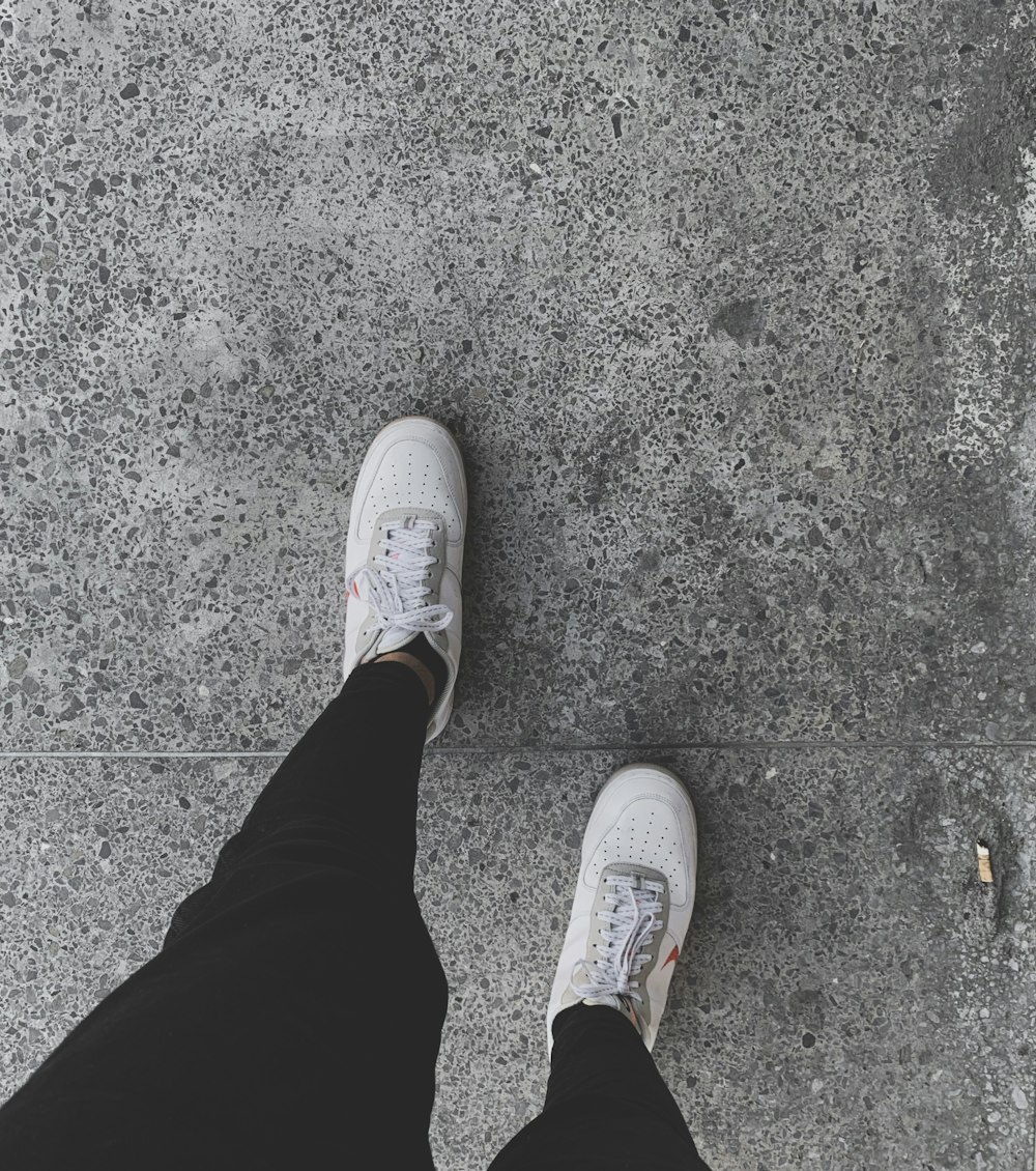 person wearing white nike sneakers