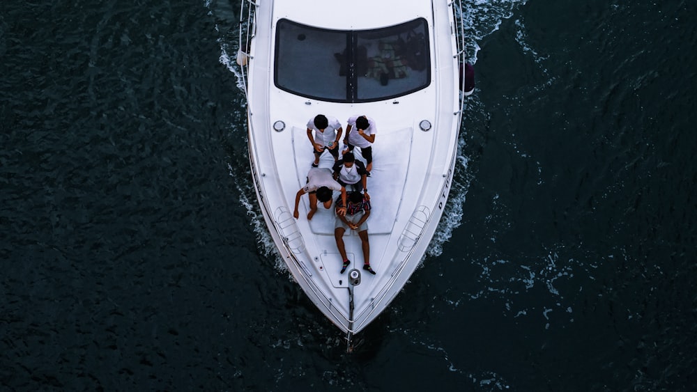 people riding on white boat during daytime