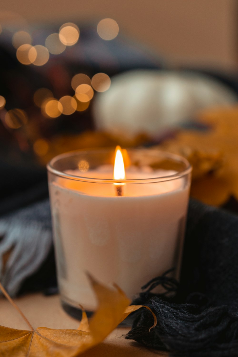 white candle in clear glass holder