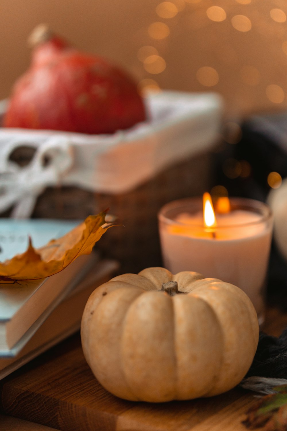 white and red pillar candle beside white and brown pumpkin