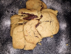 Close-up of freshly baked chocolate cookies stacked on a rustic wooden board.