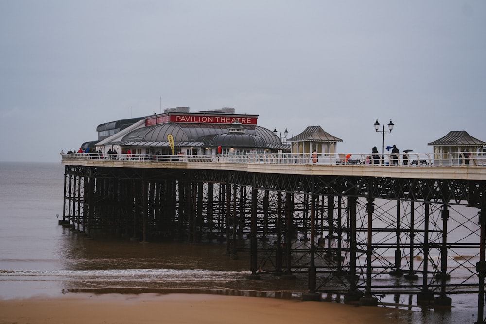 people walking on beach near bridge during daytime