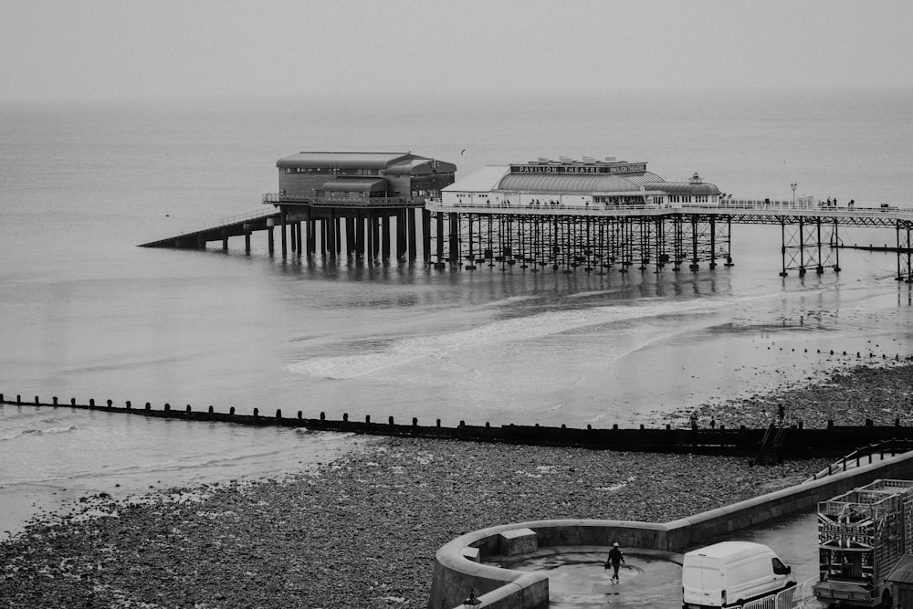 grayscale photo of a building near the body of water