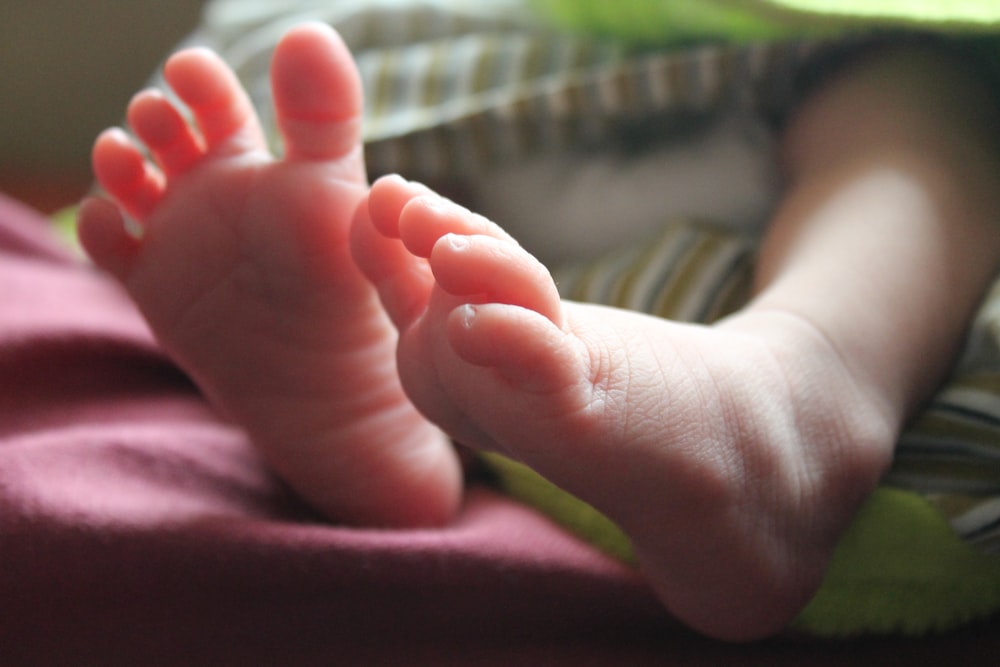 person holding babys foot