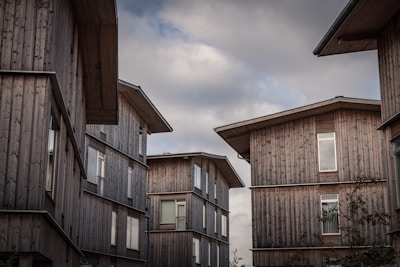 brown wooden houses under white clouds during daytime