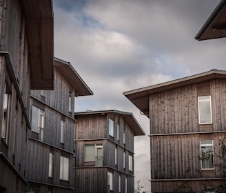 brown wooden houses under white clouds during daytime