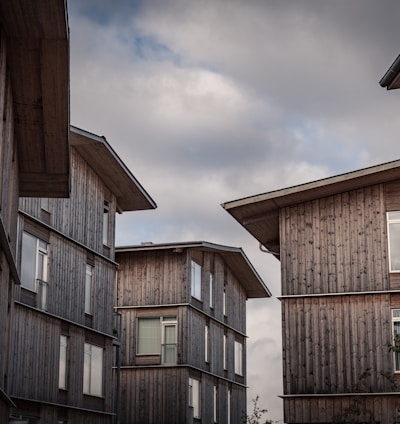 brown wooden houses under white clouds during daytime